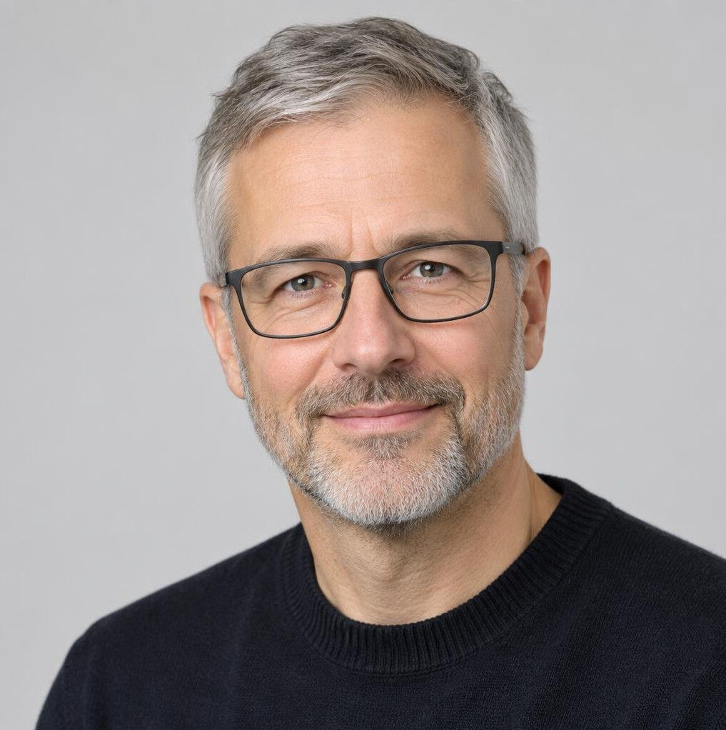 Studio portrait of a middle-aged man with glasses and a beard